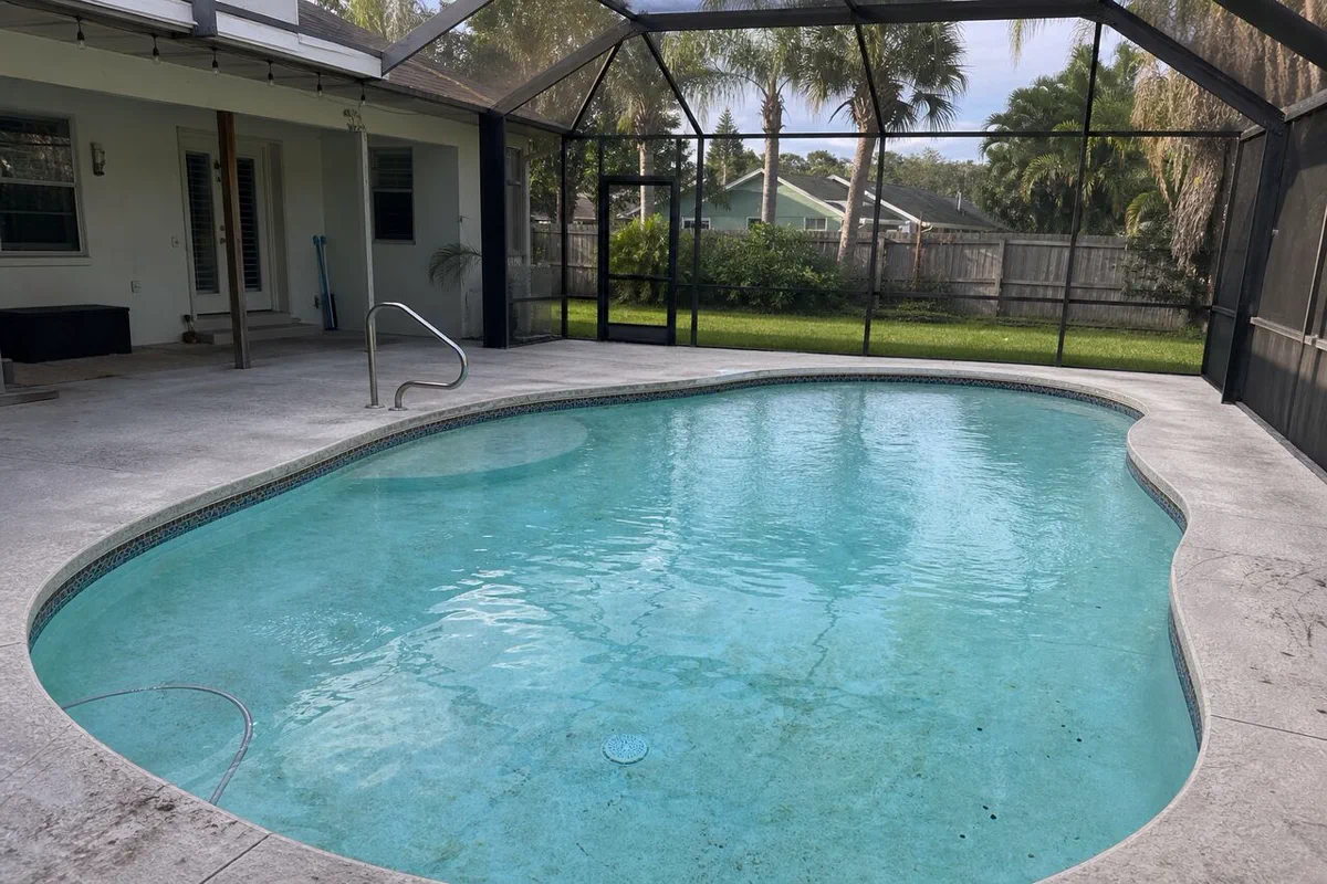 Illustrative worn marcite surface inside a screened Palm Bay-style pool lanai